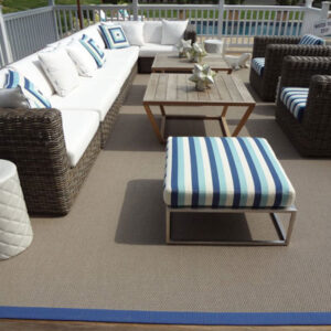 dark brown outdoor rug with blue trim and outdoor furniture
